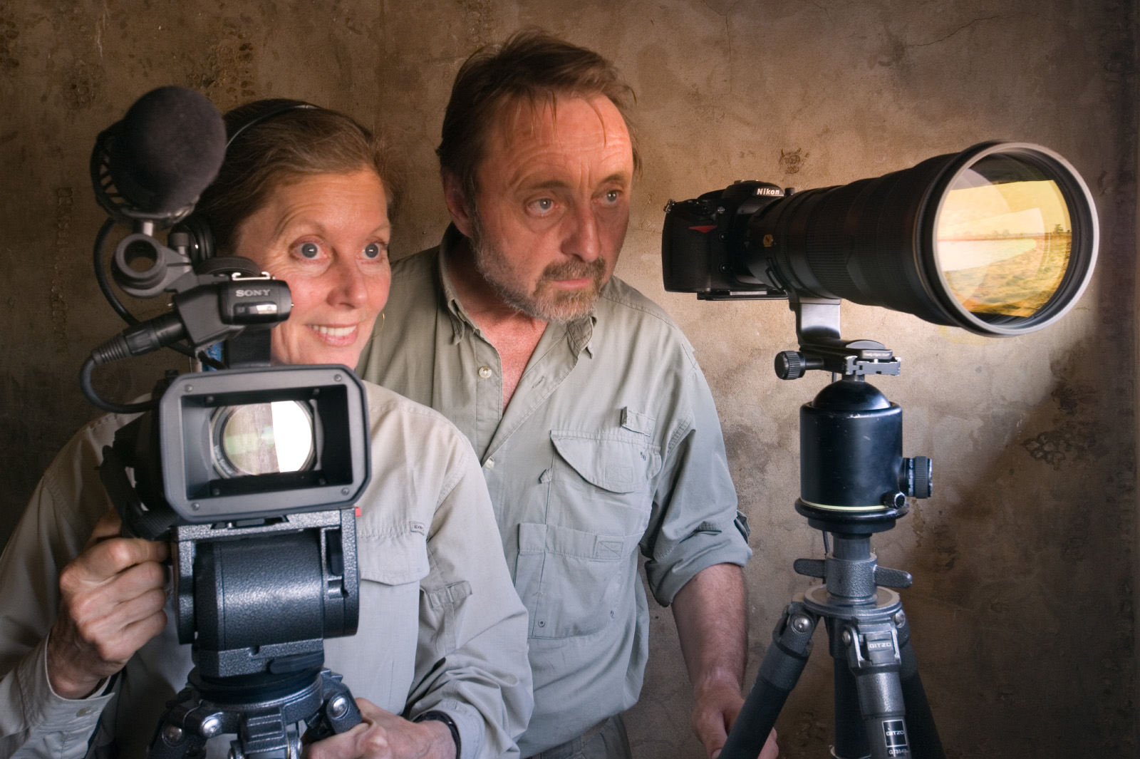Christine Eckstrom and Frans Lanting in wildlife observation bunker at water hole, Etosha National Park, Namibia
