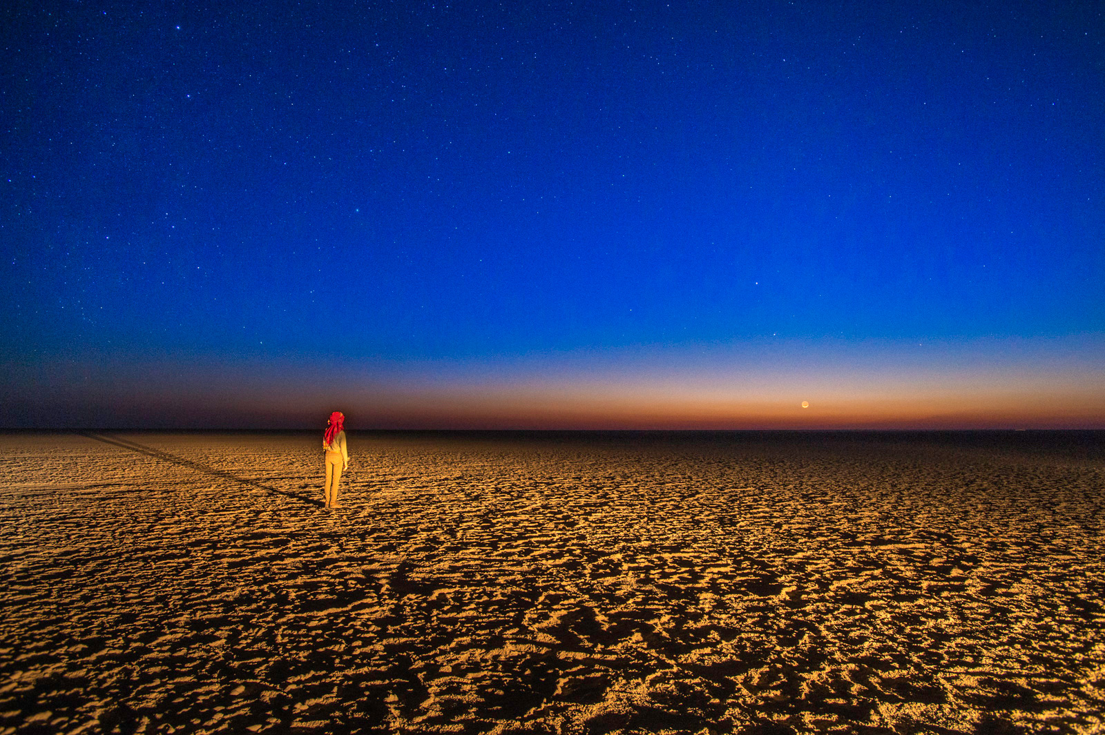 Woman watching evening sky, Makgadigadi Pan, Botswana